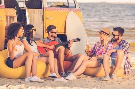 Hearing Loss Strategies That Work | Blog | Soundwave Hearing Care happy friends besid the beach with acoustic guitar