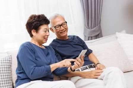 mature asian couple looking at a mobile phone