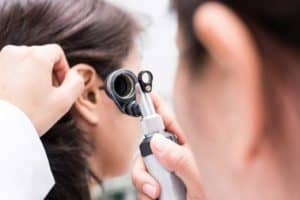 Audiologist inspecting a hearing loss patient