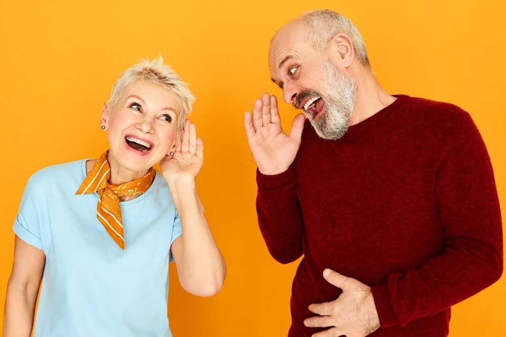 Man-and-woman-with-hearing-difficulty-laughing Man and woman with hearing difficulty laughing