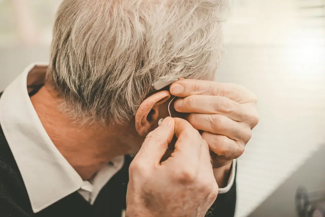 soundwavehearingcare-hearing-aids-squeak Senior gentleman removing his squeaking hearing aid