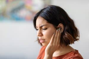 a woman holding her ear in deep thought or pain