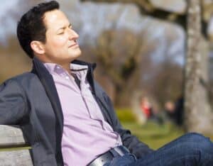 Man sitting on a bench relaxing in a park.
