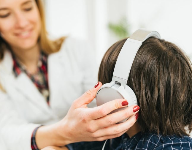 Boy wearing headphones for a hearing test.