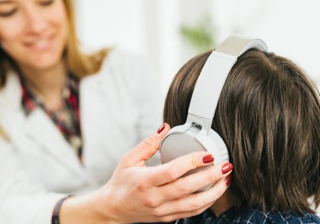 Boy wearing headphones for a hearing test.
