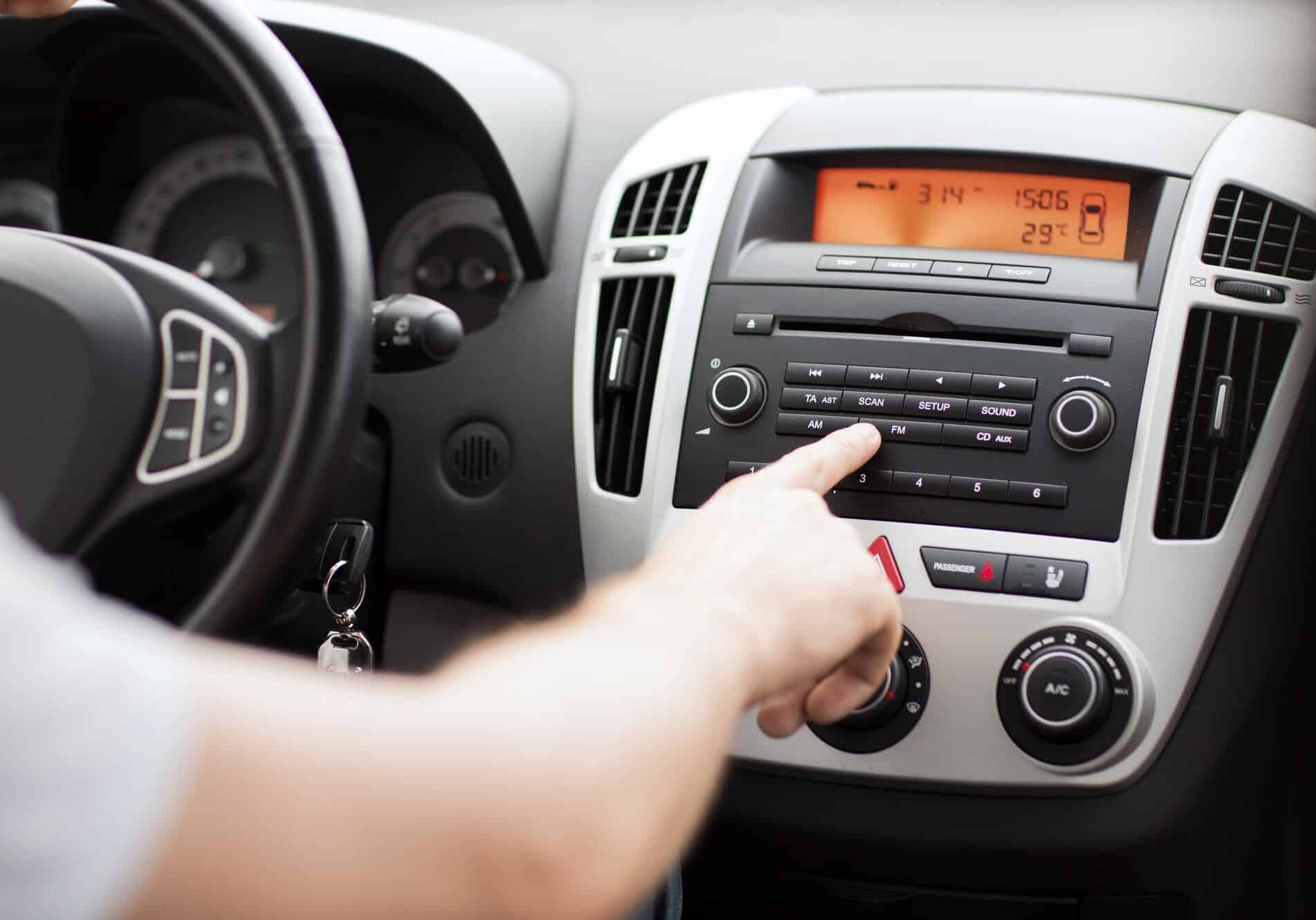 Finger pressing car radio buttons